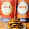Image shows chilla mix bags in blur in the back and a plate of stacked pancakes in the foreground.